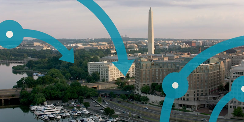 Circular arrows overlayed on a landscape photo of a government building